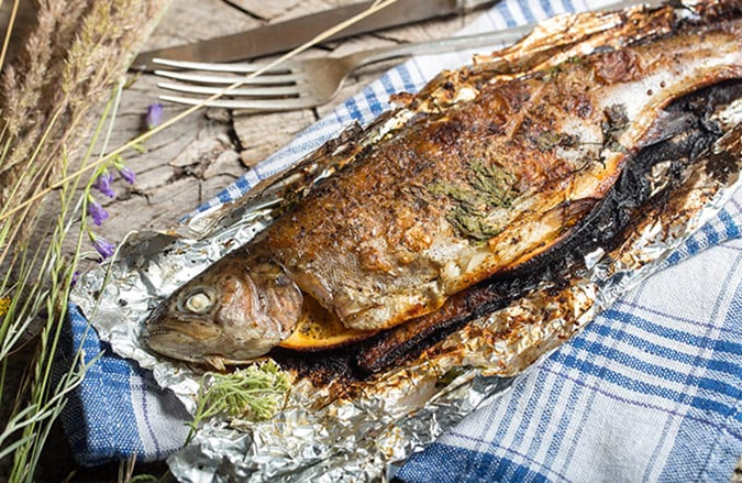 Regenbogenforelle, Grillforelle, ganze Forelle, gewürzt in Alufolie